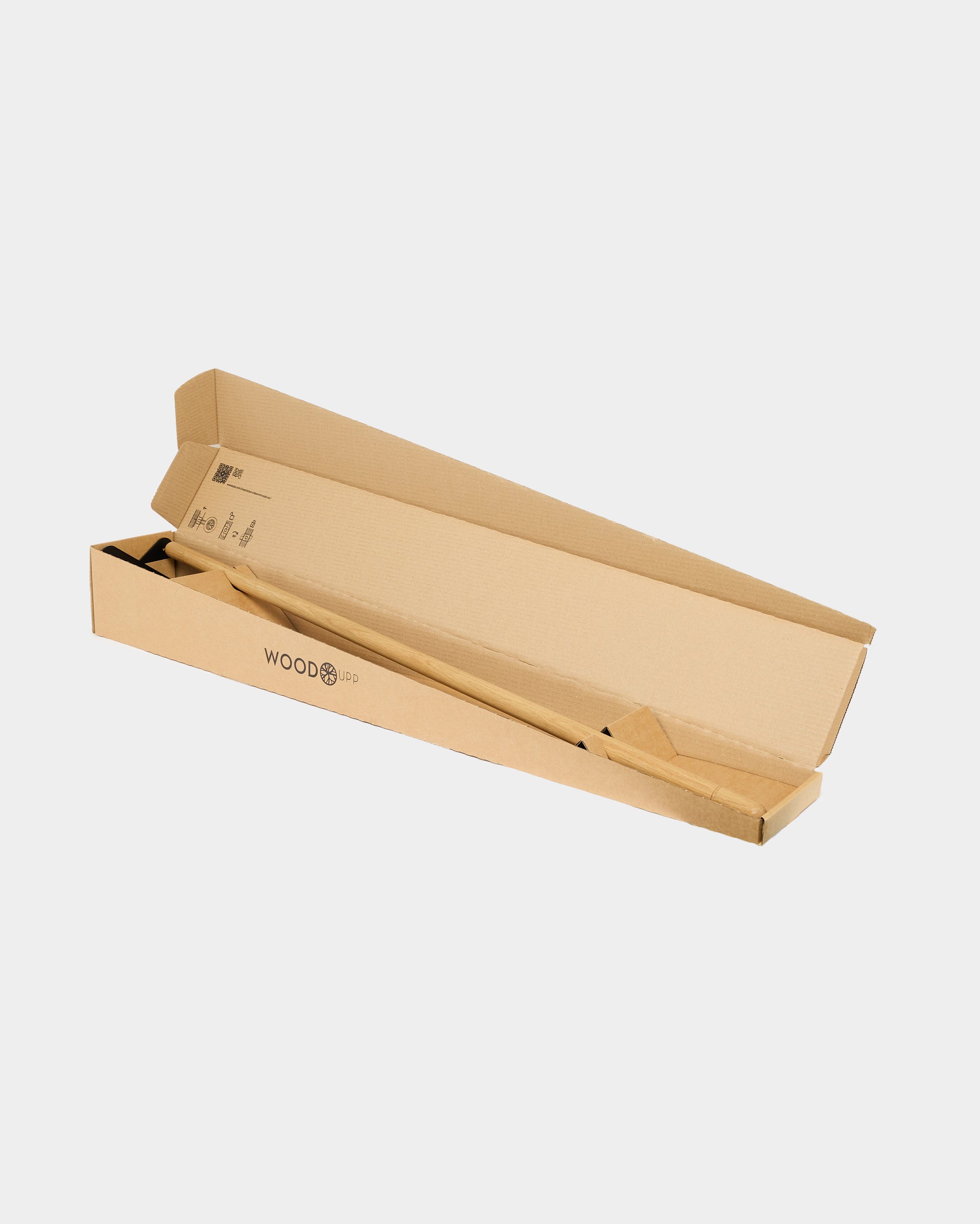 A partially opened long, flat cardboard box displays a wooden acoustic panel inside on a plain white background.